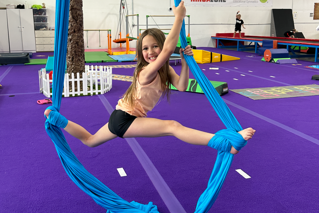 Gymnast working on aerial silks skills and improving flexibility