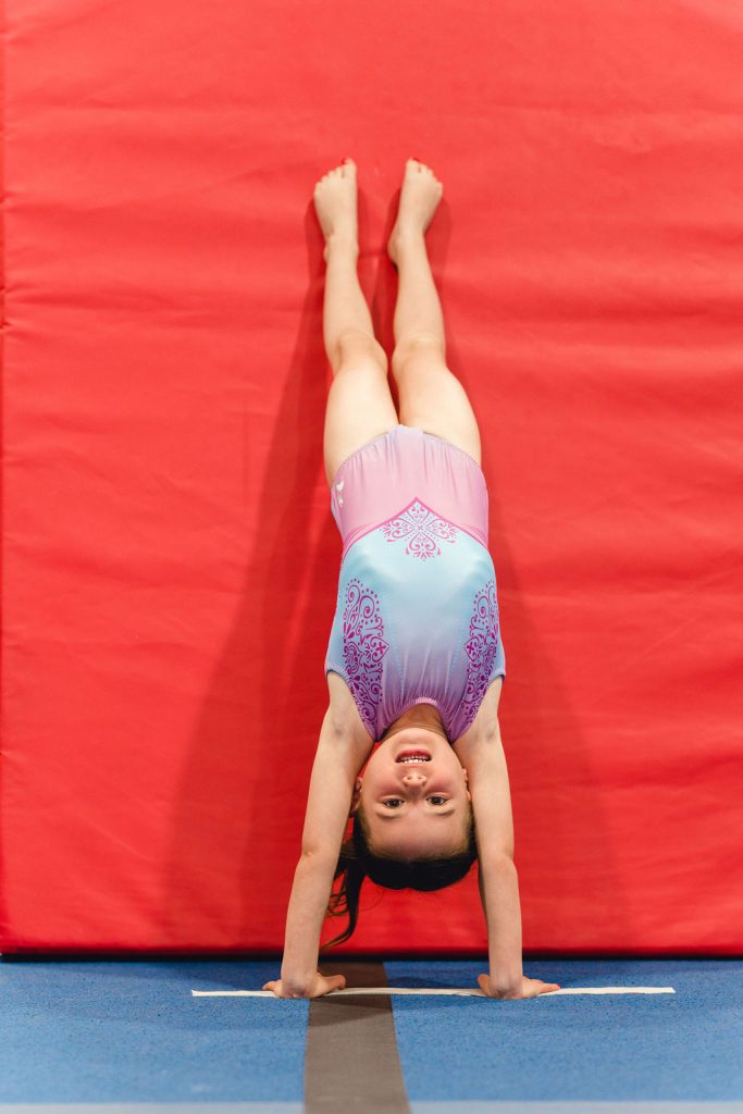 elevate recreational gymnastics girl doing a handstand and smiling