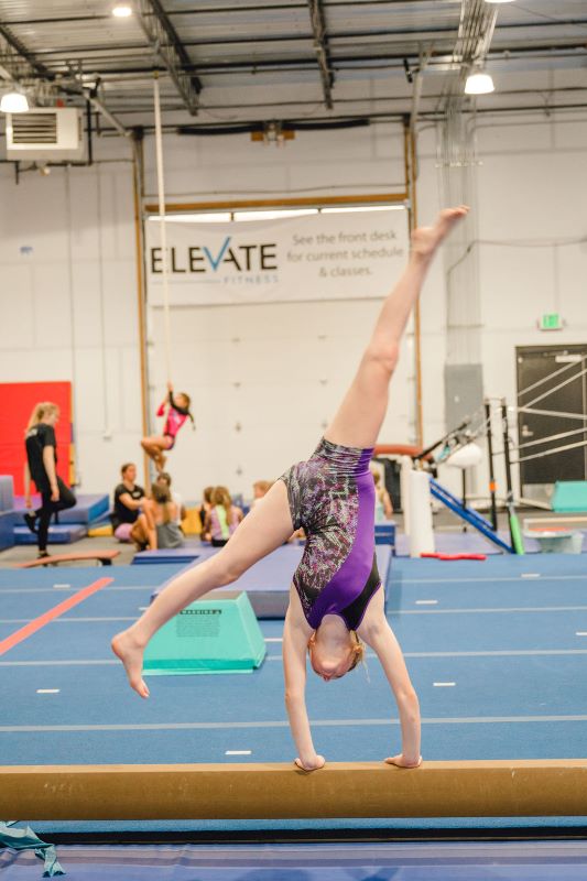 cartwheel on high beam by gymnast