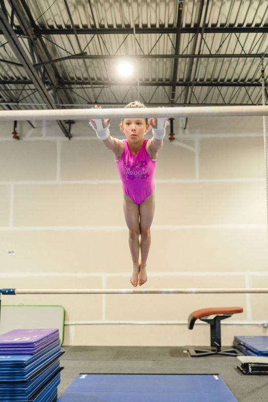 kip practice, girl jumping onto the bar in a rec class