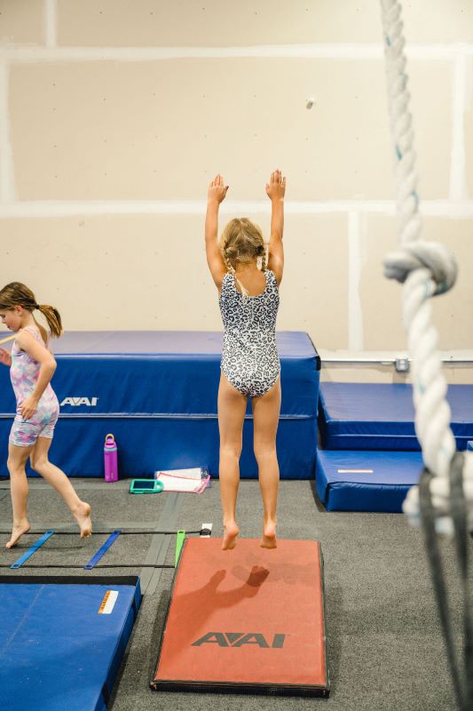 Common Gymnastics Injuries kid jumping on a spring board