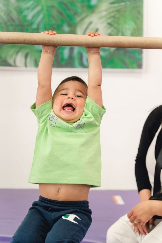 Movement-Based Learning kid hanging on bar in class