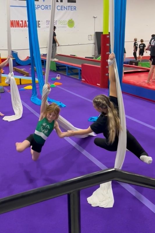 aerial silks coach and kid spinning together