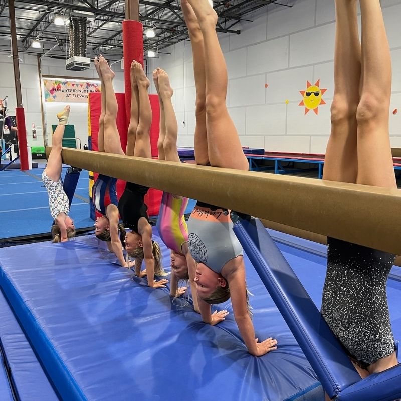 build confidence young gymnasts practicing handstand against balance beam