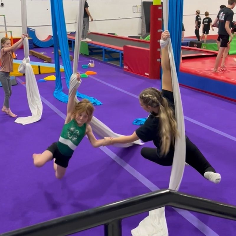 gymnastics age silk coach helping student with skill