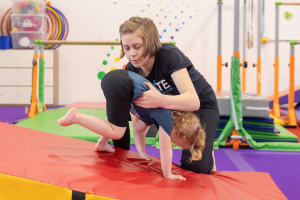 gymnastics age coach spotting young gymnast