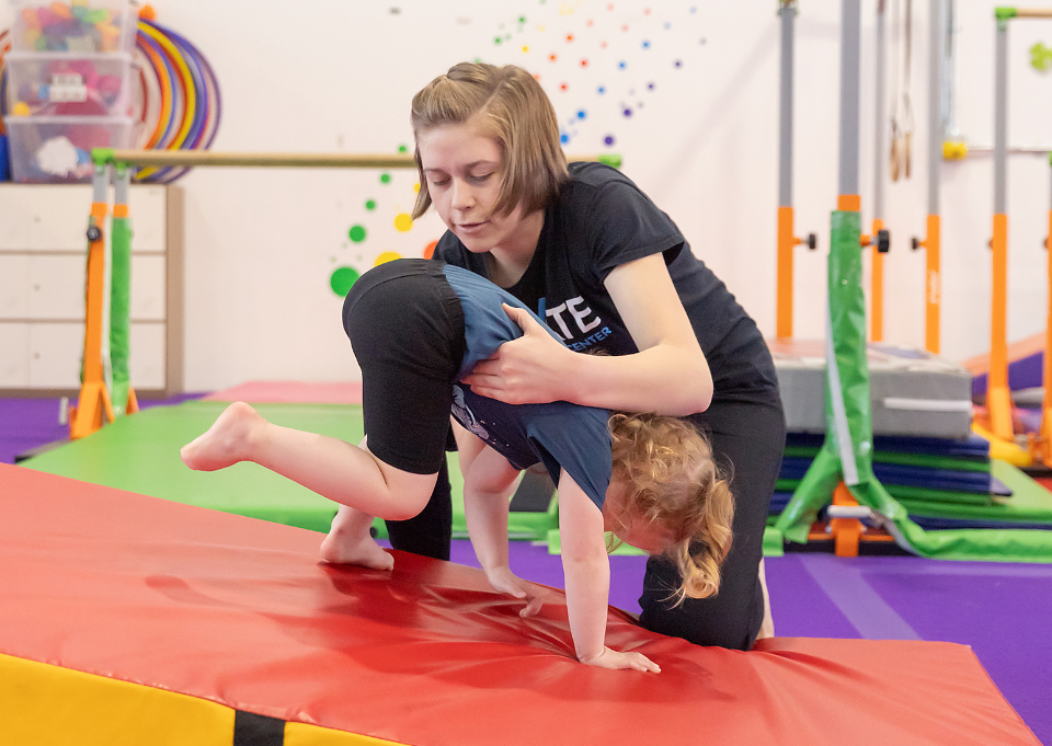 gymnastics age coach spotting young gymnast