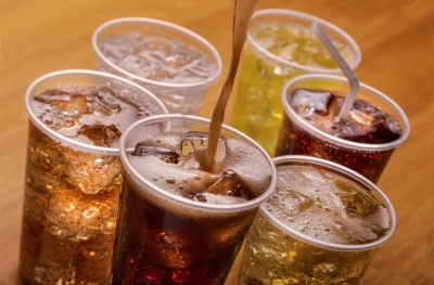 Plastic cups of varying types of carbonated drinks