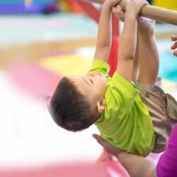 Little toddler boy working out at the indoor gym excercise